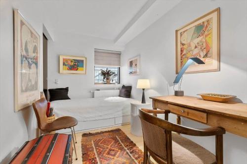 a bedroom with a bed and a desk with a desk at 84281-Ebeltoft-Hvide-Hus-Vej-3 in Ebeltoft