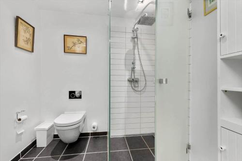 a white bathroom with a toilet and a shower at 84281-Ebeltoft-Hvide-Hus-Vej-3 in Ebeltoft