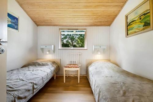 two beds in a small room with a window at 30512-Odder-Hasselvaenget-9 in Odder