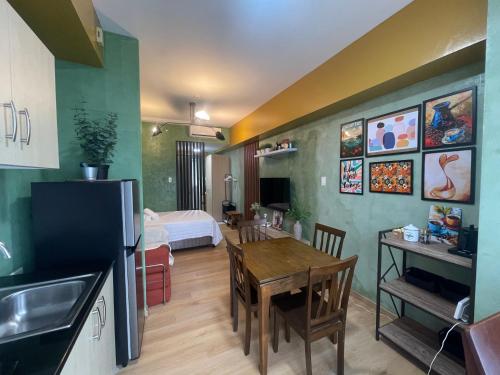 a kitchen and living room with a table and a bedroom at Rm Staycation City View SMDC in Kaybagal