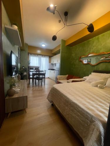 a bedroom with a large bed and a dining room at Rm Staycation City View SMDC in Kaybagal