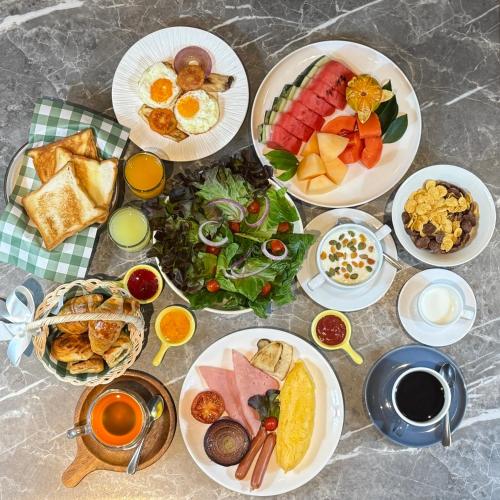 a table with many plates of food on it at Pranakorn Heritage Hotel in Bangkok