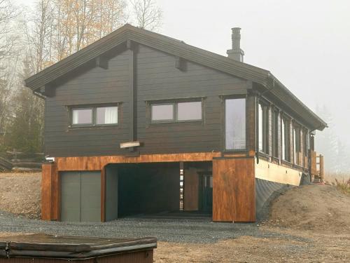 a house is being constructed with a garage at Architect-Designed Log Cabin By Myllavannet in Lunner