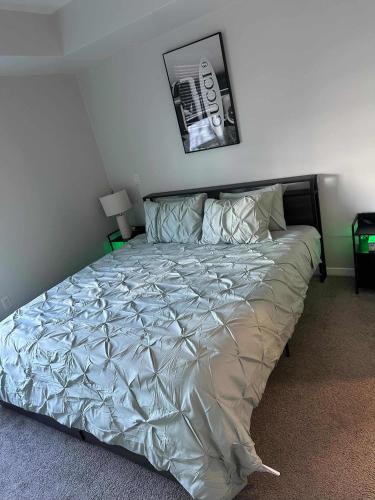 a bed in a bedroom with a poster on the wall at DTLA prime one bedroom steps away from Crypto in Los Angeles