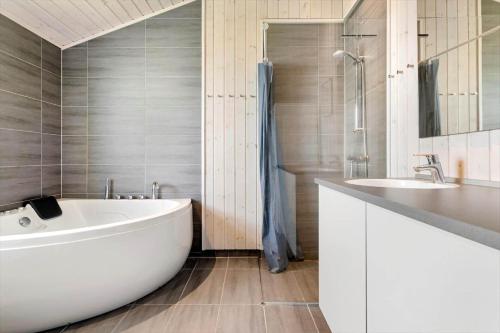a bathroom with a large white tub and a sink at 30451-Odder-Strandvaenget-7 in Odder