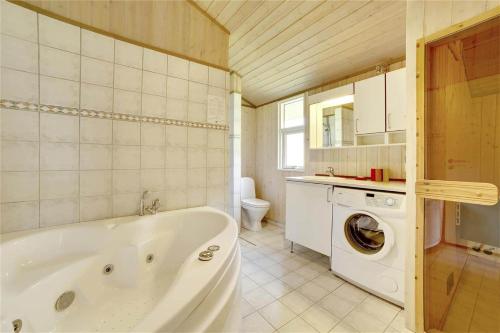 a bathroom with a tub and a washing machine at 30727-Odder-Alrovej-203-A in Odder