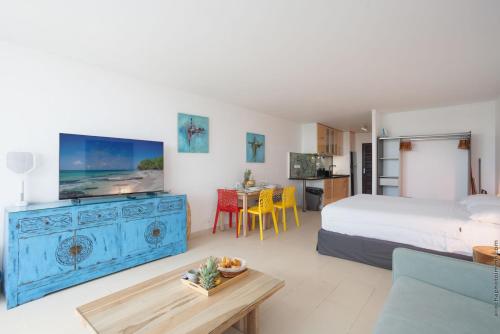 a bedroom with a bed and a living room at Lounge modern chill studio Orient Bay in Orient Bay