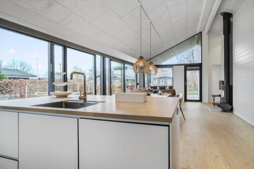 a kitchen with white cabinets and a large group of windows at 40149-Juelsminde-Gl-Dykjaer-14 in Juelsminde