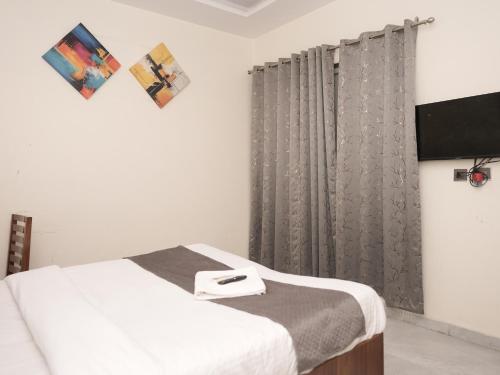 a bedroom with a bed with a gray curtain at Life Tree Hotel and Banquet Hall, Sector 63A in Noida