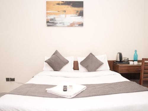 a white bed with two pillows and a table at Life Tree Hotel and Banquet Hall, Sector 63A in Noida