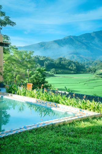 a pool with a view of a field and mountains at Campo De Sole Villa Hoa Binh in Hòa Bình