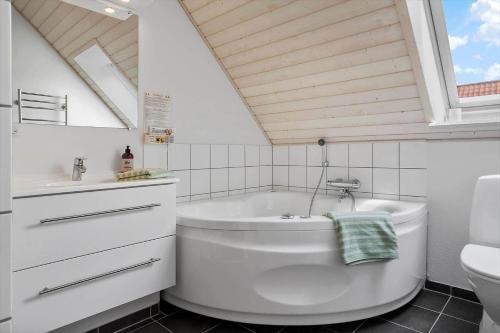a bathroom with a tub and a toilet and a sink at 40168-Juelsminde-Strandengen-52 in Juelsminde