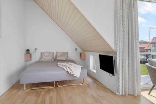 a bedroom with a bed and a flat screen tv at 40168-Juelsminde-Strandengen-52 in Juelsminde