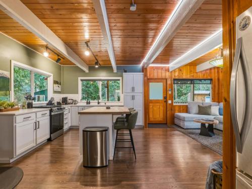 a kitchen with white cabinets and wood ceilings at Ravens Retreat in Index