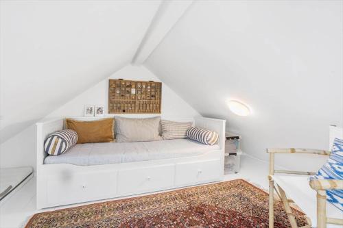 a white couch in a white room with a rug at 40155-Juelsminde-Bugten-31 in Juelsminde