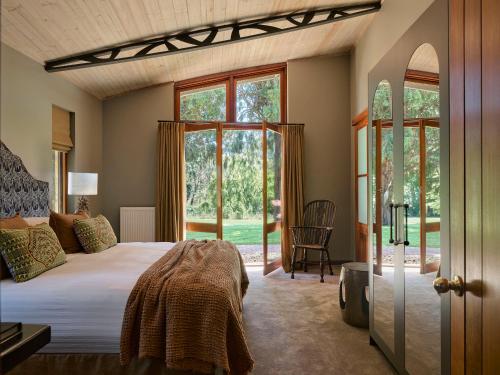 a bedroom with a bed and some windows at Bendooley Estate in Berrima