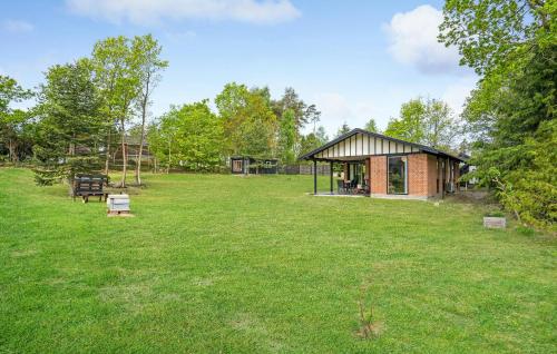 a small building in the middle of a field at Two-Bedroom Holiday Home In Knebel in Knebel