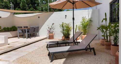 a patio with two chairs and an umbrella at Casa Venado in Caucel