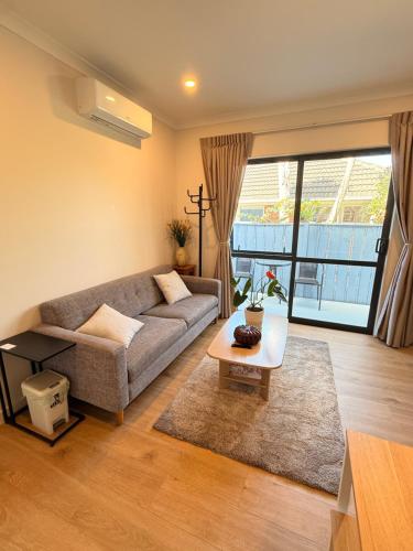 a living room with a couch and a table at Modern Private 2BR Unit in Takapuna in Auckland
