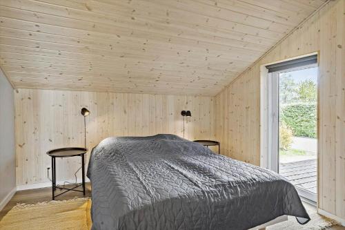 a bedroom with a bed and two tables and a window at 30465-Odder-Stakket-Torn-9 in Odder