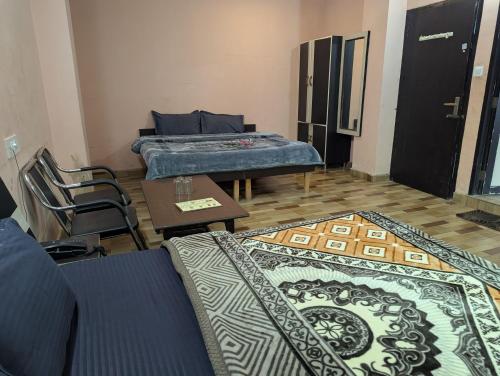 a living room with two beds and a table and carpet at Silver oak Hotel and Restaurant in Pāndoh