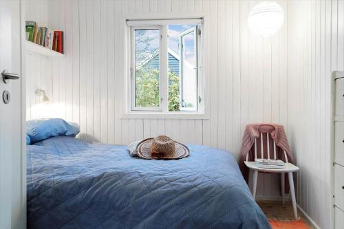 a bedroom with a bed with a hat on it at 40161-Juelsminde-Bugten-30 in Juelsminde