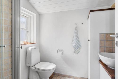 a white bathroom with a toilet and a sink at 30594-Odder-Toldvejen-45-H in Odder