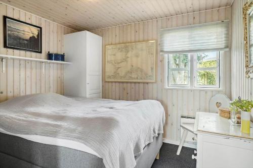 a bedroom with a bed and a desk and a window at 40159-Juelsminde-Mirabellevej-1 in Juelsminde