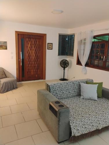 a living room with a couch and a bed at Casa Tia Celinha e Cafeteria in Teresópolis