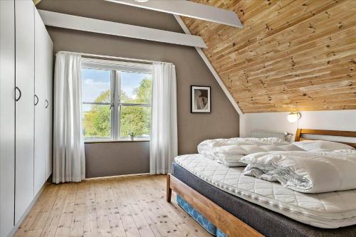 a bedroom with a large bed and a window at 40117-juelsminde-Gludvej-7 in Juelsminde