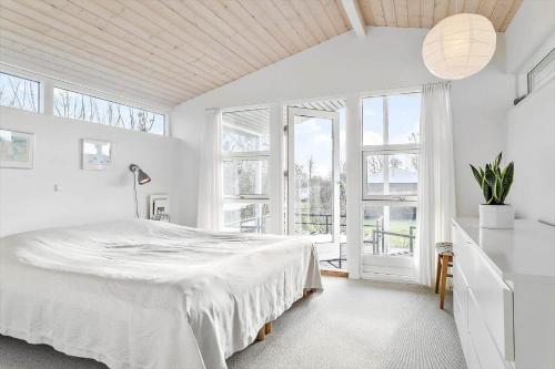 a white bedroom with a large bed and windows at 30461-Odder-Hulager-6 in Odder
