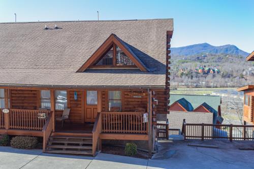 a log cabin with a porch and a roof at Steps from Pkwy! Hot Tub~Pool Access~Fast WiFi in Pigeon Forge