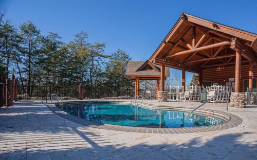 a swimming pool with a gazebo and a house at Steps from Pkwy! Hot Tub~Pool Access~Fast WiFi in Pigeon Forge