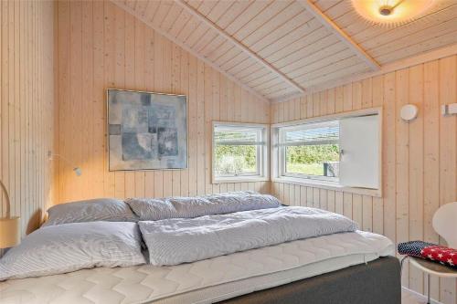 a large bed in a room with two windows at 40146-Juelsminde-Elmealle-24 in Juelsminde