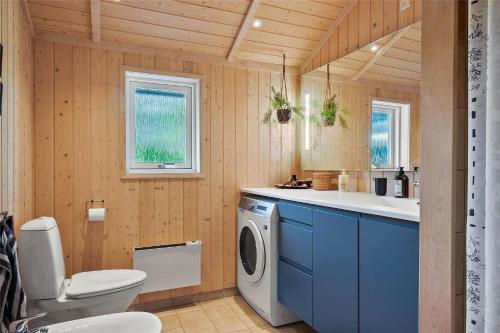 a bathroom with a toilet and a washing machine at 40146-Juelsminde-Elmealle-24 in Juelsminde