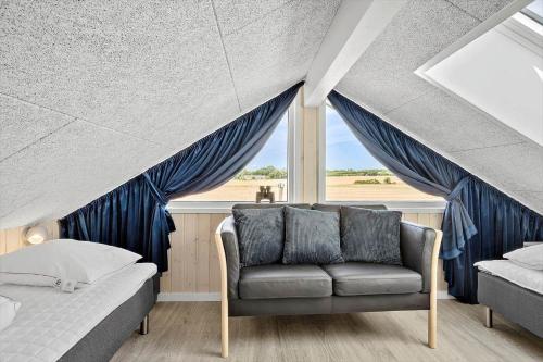 a bedroom with a couch and a bed and a window at 30484-Odder-Strandvaenget-60 in Odder