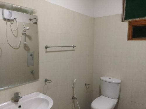 a bathroom with a toilet and a sink at Aarya hotel in Pinnawala
