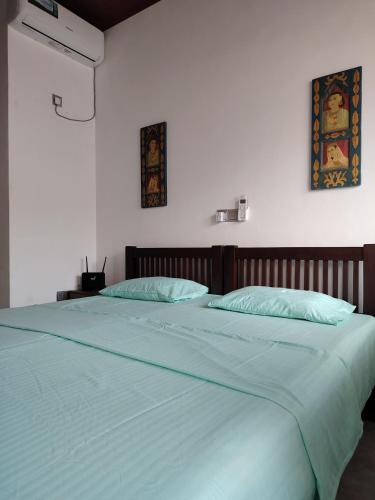 a large bed with blue sheets in a bedroom at Harbor View AC Apartment in Ambalangoda