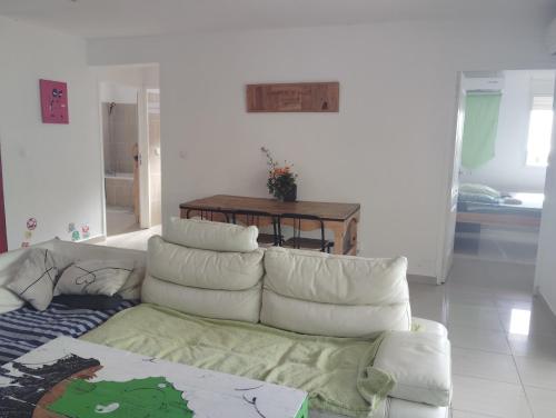 a living room with a white couch and a table at La chambre Ganesh in Saint-André