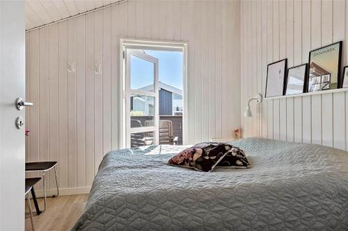 a bedroom with a bed and a large window at 40501-Juelsminde-Pot-Strandby-251 in Sønderby