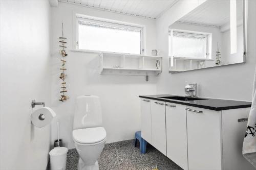 a white bathroom with a toilet and a sink at 30609-Odder-Spovevej-1 in Odder