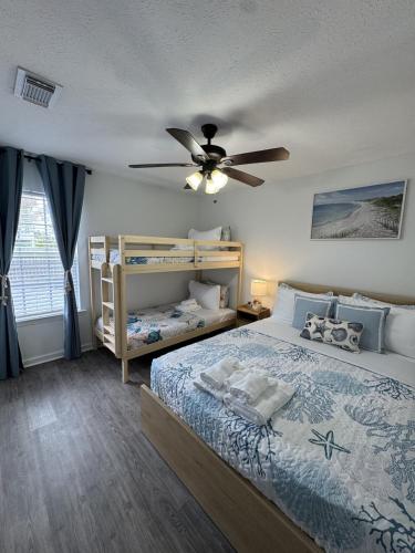 a bedroom with a bed and a ceiling fan at Sunset Beachside Getaway, 6 mins WALK to the Beach in Panama City Beach