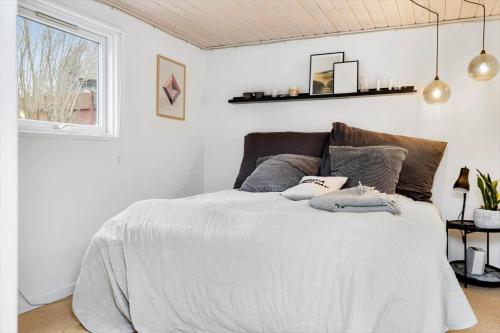a white bedroom with a bed with pillows on it at 40162-Juelsminde-Gludvej-9 in Juelsminde