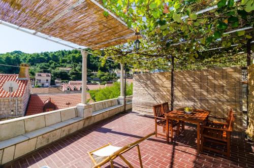 a patio with a table and chairs on a balcony at Eco Apartments Kate in Suđurađ