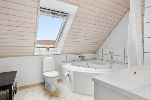 a bathroom with a tub and a toilet and a window at 40100-Juelsminde-Strandengen-32 in Juelsminde