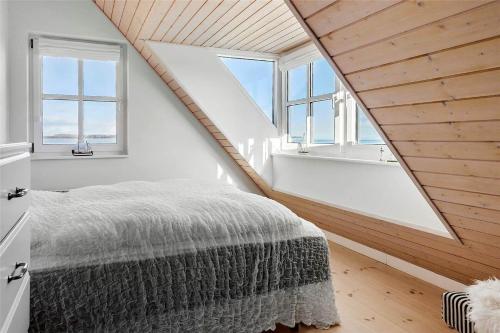 a attic bedroom with a bed and two windows at 40100-Juelsminde-Strandengen-32 in Juelsminde