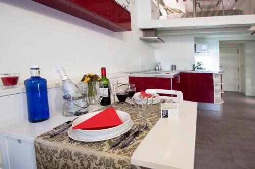 eine Küche mit einem Tisch mit Teller und Weingläsern in der Unterkunft Loft las letras in Madrid