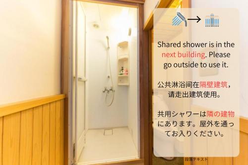a shower in a bathroom with a sign on the door at Nagomi-Ryokan Yuu in Kyoto
