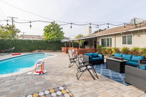 a backyard with a pool and chairs and a house at Private Pool Retreat Near Disney Game Room Firepit in Fullerton