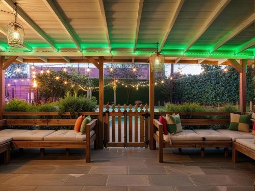 a pergola with benches and lights on a patio at Private Pool Retreat Near Disney Game Room Firepit in Fullerton